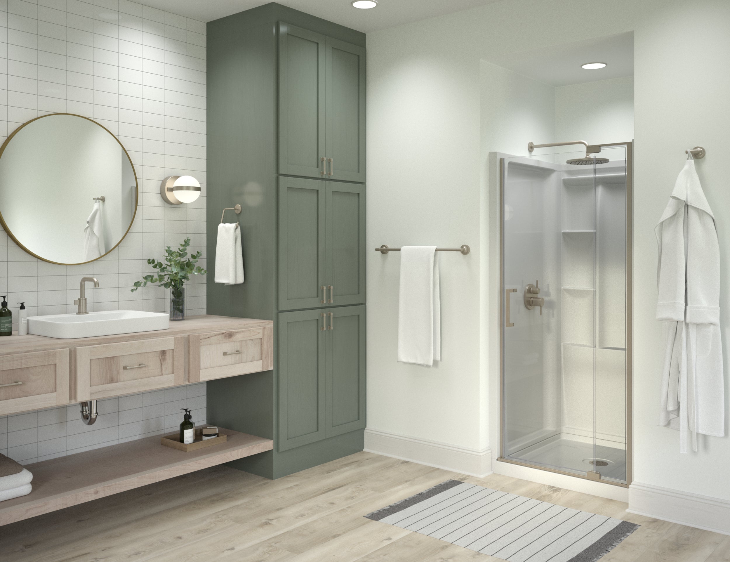 A modern bathroom interior featuring a tall sage green cabinet, a walk-in shower with glass doors, a floating light wood vanity with a white sink, white subway tile, and a round gold-framed mirror.