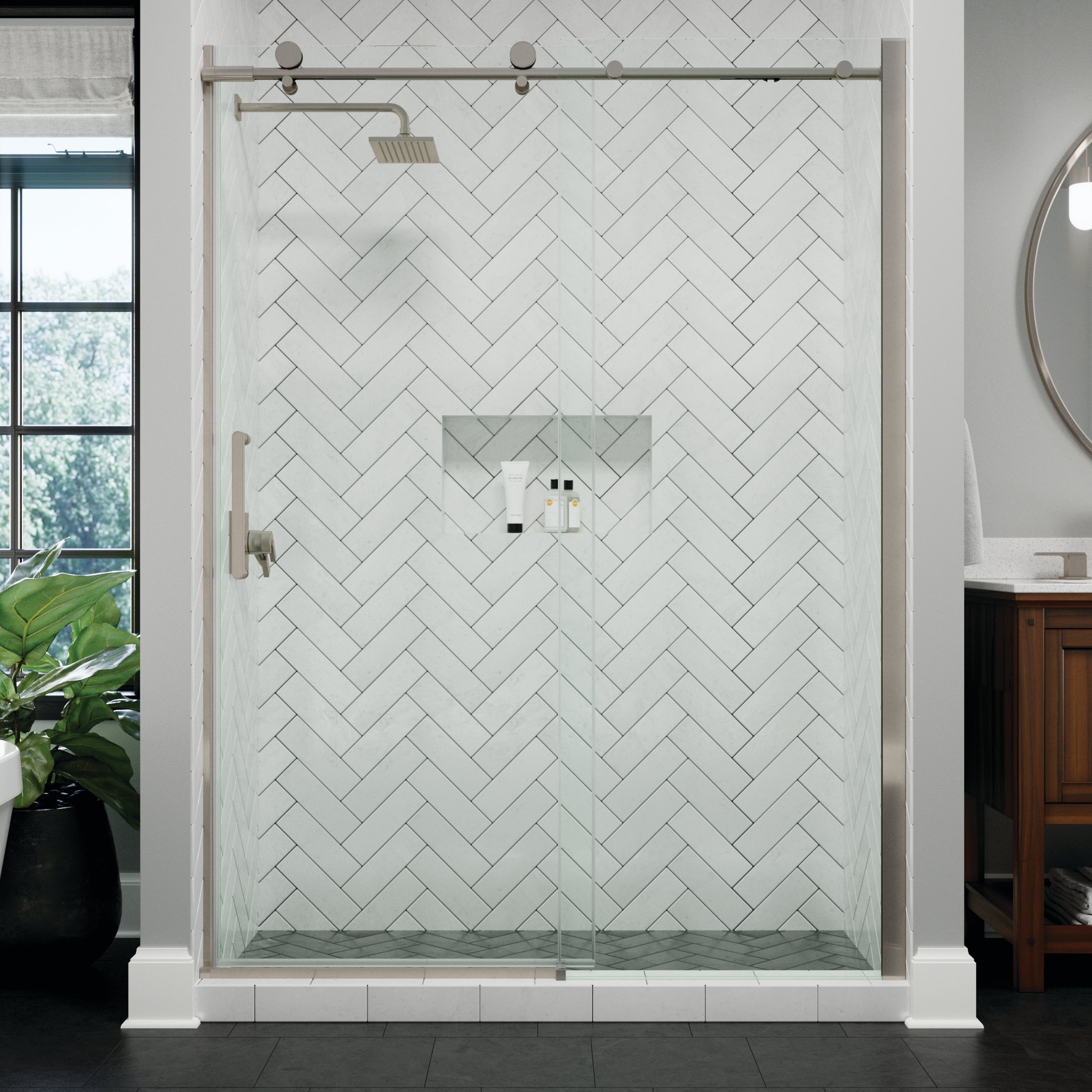 A modern frameless glass shower door installed in a walk-in shower enclosure with white herringbone tile walls and a chrome shower system, shown in a bathroom setting.